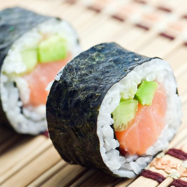 Rotolino di sushi con salmone e cetriolo.